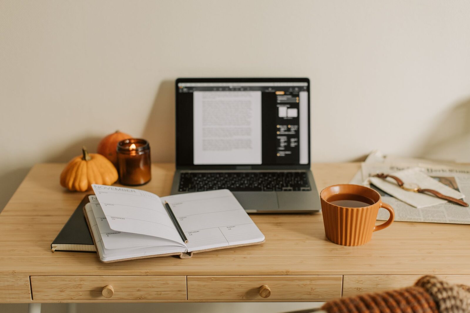 A notebook and coffee on a warm wooden desk